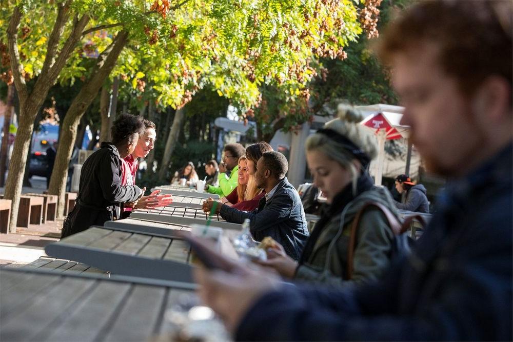 Students talking and sitting outside on campus.