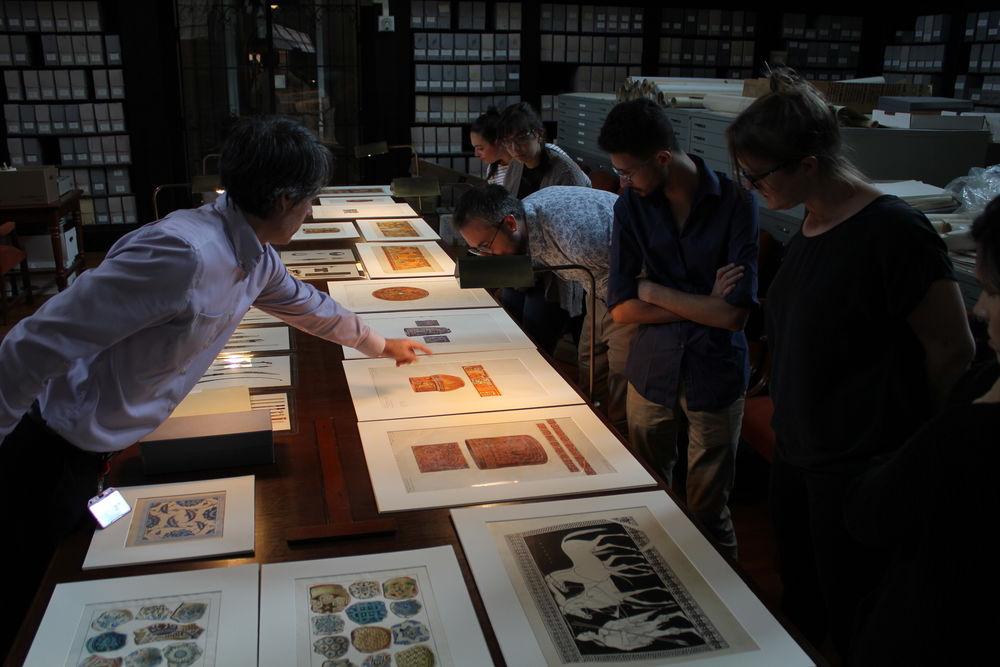 Tyler faculty examines prints with students. 